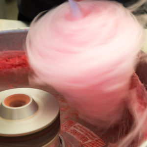 Pink cotton candy spinning fast as it is being made in a machine.