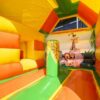 Chateau gonflable pour enfant, couleur orange - vert - jaune, avec toboggan